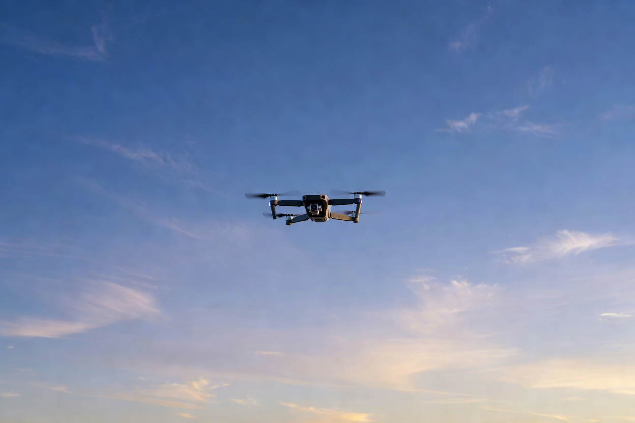 Small drone flying against open sky