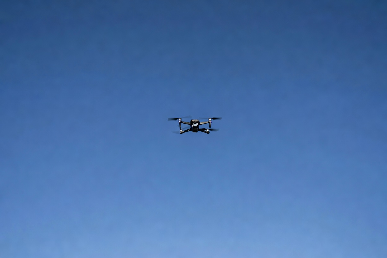 Small drone flying against a wide open sky